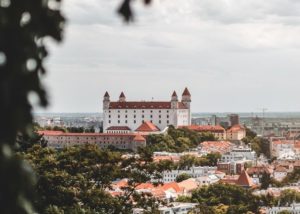 A view of a city from a hill with a structure named Bratislava Castle.