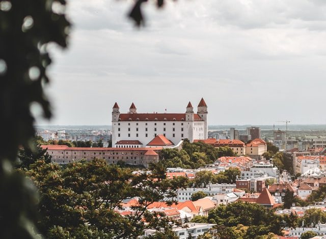 A view of a city from a hill with a structure named Bratislava Castle.